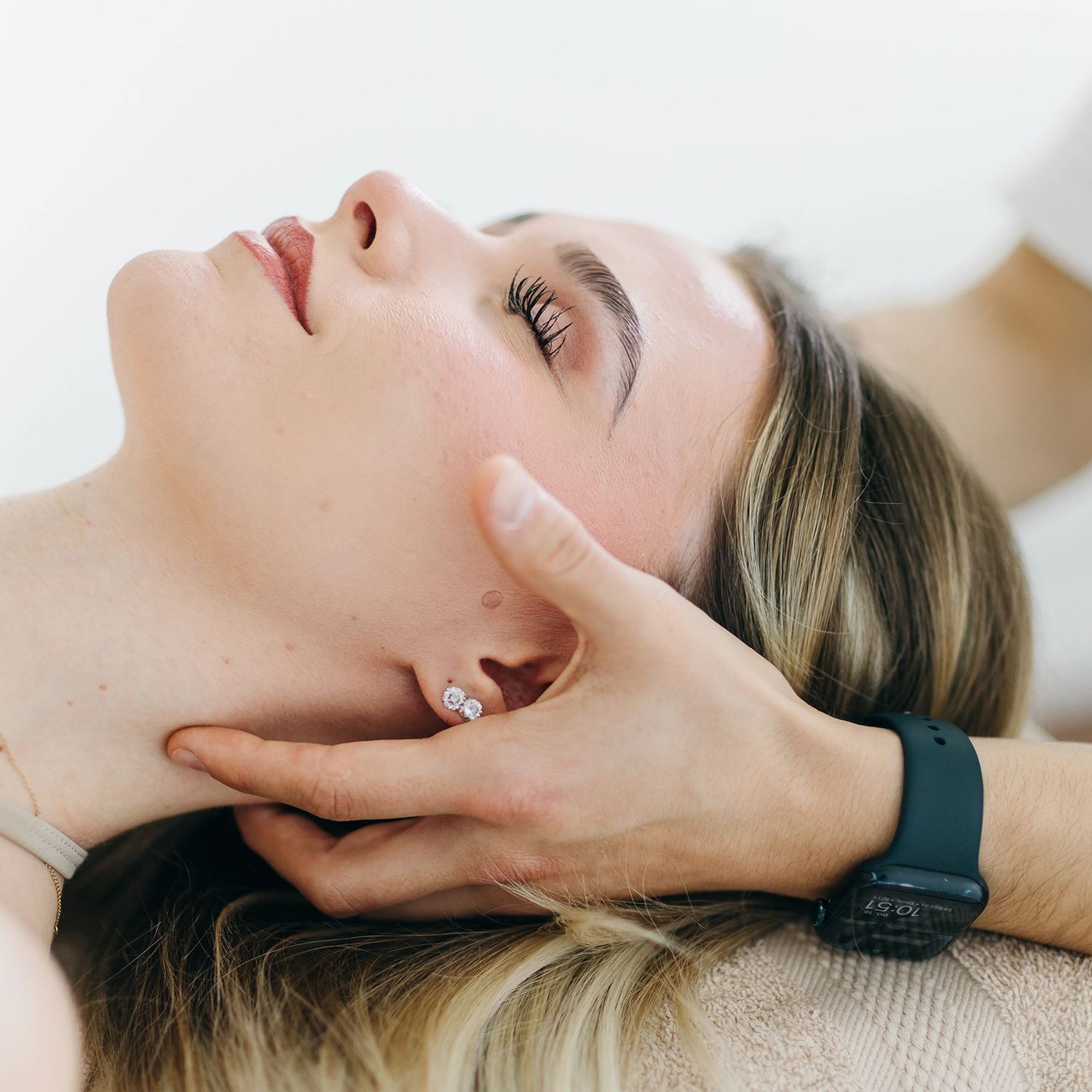 Nahaufnahme einer manuellen Behandlung am Nacken einer Patientin – Sportphysiotherapie und Rehabilitation in Oberhaching.