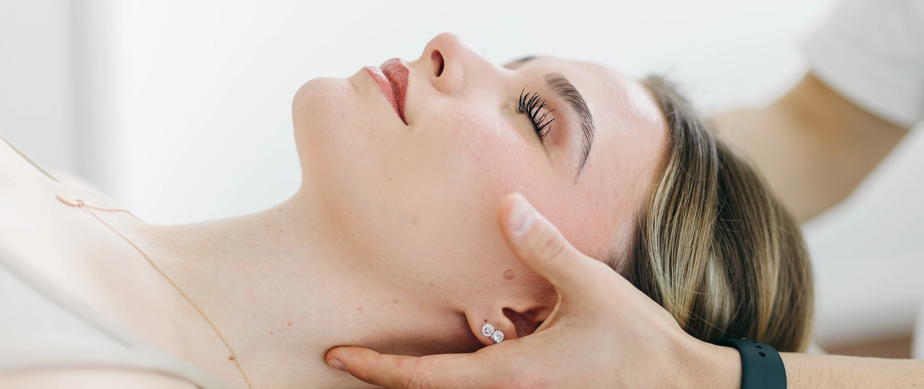 Nahaufnahme einer manuellen Behandlung am Nacken einer Patientin – Sportphysiotherapie und Rehabilitation in Oberhaching.