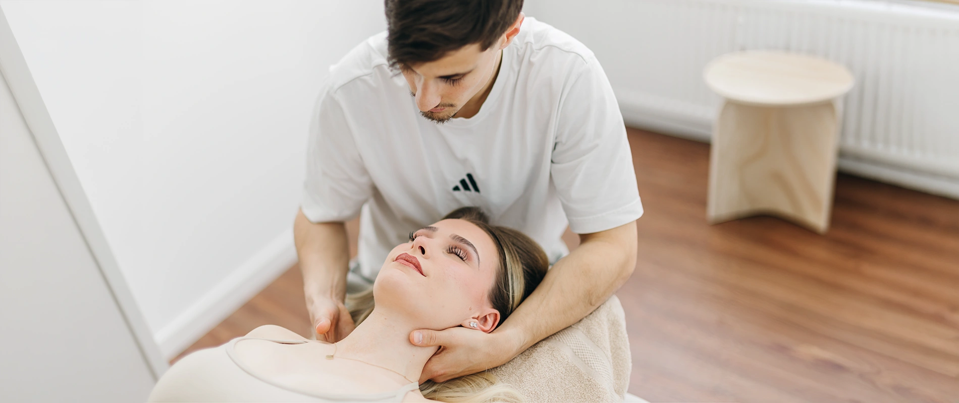Nahaufnahme einer manuellen Behandlung am Nacken einer Patientin – Sportphysiotherapie und Rehabilitation in Oberhaching.
